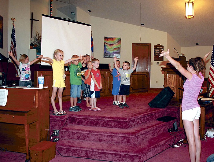 Children in preschool and kindergarten sing songs in music class at Lebanon Baptist Church Vacation Bible School, McGirk, Thursday evening. At right is class instructor Abby Bilyeu.