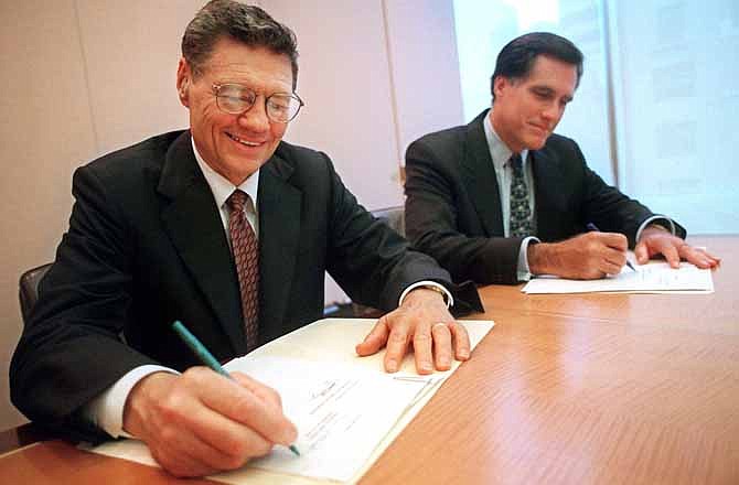 In this Sept. 25, 1998 file photo, provided by Domino's Pizza, Thomas Monaghan, founder and chairman of Domino's Pizza, Inc., left, and Mitt Romney, managing director of Bain Capital, Inc., sign an agreement for Monaghan to sell a "significant portion" of his stake in the company to Bain Capital, in New York. A businessman at his core, Mitt Romney was legendary in the private sector for his reliance on reams of information and extensive research to decide which companies to take over. 