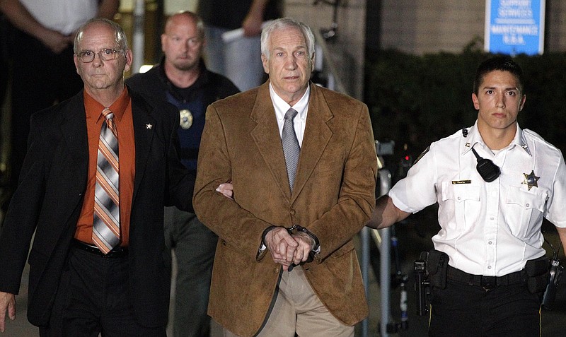 Former Penn State University assistant football coach Jerry Sandusky, center, leaves the Centre County Courthouse in custody Friday with Centre County Sheriff Denny Nau, left, after being found guilty of multiple charges of child sexual abuse in Bellefonte, Pa. Sandusky was convicted of sexually assaulting 10 boys over 15 years, accusations that had sent shock waves through the college campus known as Happy Valley and led to the firing of Penn State's beloved Hall of Fame coach, Joe Paterno. 