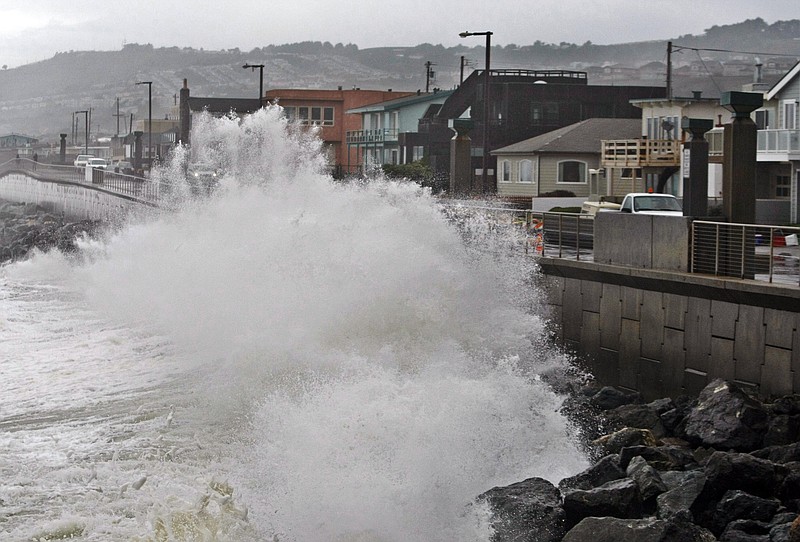 Waves pound a wall near buildings in Pacifica, Calif., during a rain storm in January 2010. A new federal report gives the West Coast its best look yet at what to expect from rising sea levels due to climate change. The report issued by the National Research Council on Friday says Southern and central California can expect sea levels to rise in a range of about three feet over the next century, while Northern California, Oregon and Washington can expect the range to be less - around two feet.