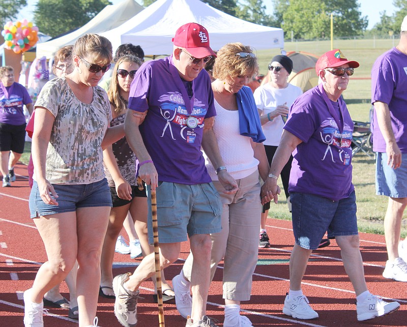 Laura Fennewald (far left) and Sue Johnson (third from left) support their father, Tony Lander (second from left) and grandmother, Darlene Lander (far right) during the Survivors' Lap at the 2012 Relay for Life of Callaway Cancer Friday night. Tony Lander is currently battling lung cancer. Darlene Lander first battled thyroid cancer 30 years ago and has been cancer free for 12 years after a third battle - that time with lung cancer.