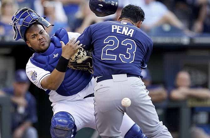 Tampa Bay Rays' Carlos Pena, right, scores as Kansas City Royals catcher Brayan Pena drops the ball during the first inning of a baseball game Tuesday, June 26, 2012, in Kansas City, Mo. 