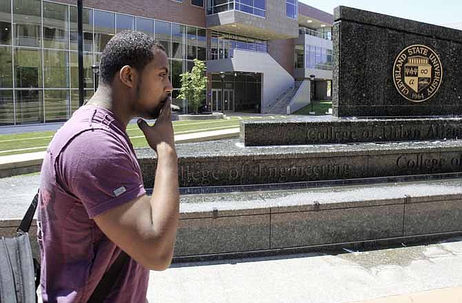 In this Tuesday, June 26, 2012 photo, Menelik Mengesha, 23, a junior studying civil engineering at Cleveland State University smokes a cigarette on campus in Cleveland. Smoking shouldn't be one of the things kids learn at college, say state officials pushing sweeping tobacco-use bans on campuses across the country.