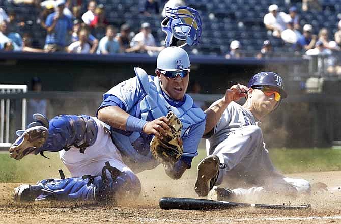 Kansas City Royals catcher Salvador Perez, right, loses his mask after tagging out Tampa Bay Rays' Ben Zobrist at home during the eighth inning of a baseball game, Wednesday, June 27, 2012, in Kansas City, Mo. Zobrist tried to score from third on a fielder's choice hit by Will Rhymes.