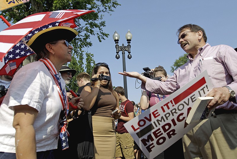 Steve Ciccarelli of Annandale, Va., right, a proponent of President Barack Obama's health care law, argues Thursday with an opponent on the issue, Susan Clark, of Washington, outside the Supreme Court while awaiting the court's ruling on the law. 