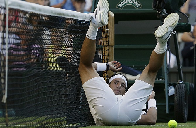 Rafael Nadal lies on the court after failing to return a shot to Lukas Rosol during a second round men's singles match at the All England Lawn Tennis Championships at Wimbledon, England.
