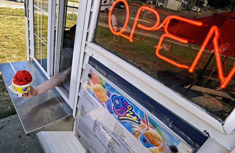 Levi Doyle-Barker calls out a shave ice order ready for pickup as a steady stream of customers decide the best way to beat Friday's heat was to stop by SnoBiz on Missouri Boulevard.