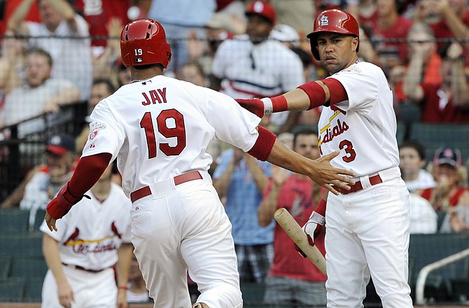 Jon Jay is congratulated by Cardinal teammate Carlos Beltran after scoring on a double by Matt Holliday during Wednesday night's game against the Rockies at Busch Stadium.