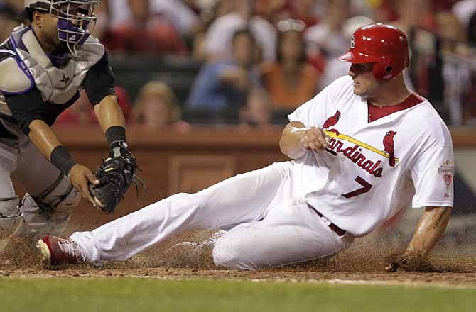 St. Louis Cardinals' Matt Holliday (7) scores as Colorado Rockies catcher Wilin Rosario applies the late tag in the fifth inning of their baseball game, Thursday, July 5, 2012, in St. Louis. Holliday is replacing teammate Yadier Molina on the National League All-Star team.