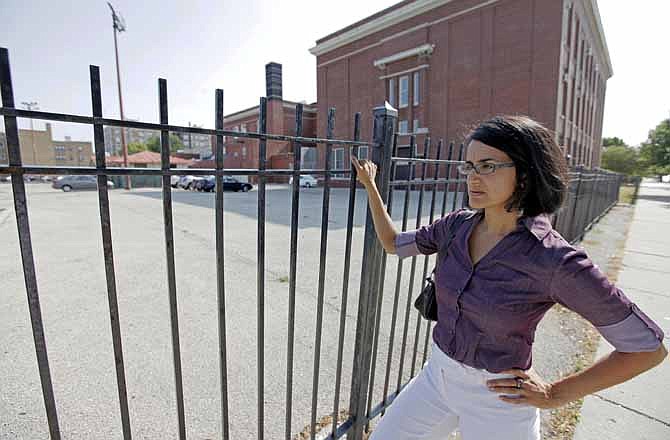 In this July 5, 2012 photo, Amisha Patel, director of Grassroots Collaborative, a community-labor coalition, stands outside of Emmet Elementary School on Chicago's West Side. Patel is among skeptics who worry that investor-funded projects under the Chicago Infrastructure Trust could end up costing taxpayers more, and could skip over poorer neighborhoods where private firms may see less profit.