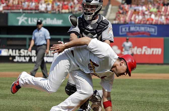 St. Louis Cardinals' Allen Craig, bottom, is tagged out by Miami Marlins catcher Brett Hayes after being caught in a rundown between third and home in the second inning of a baseball game on Saturday, July 7, 2012, in St. Louis. 
