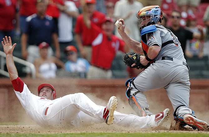 David Freese of the Cardinals looks for the call as Marlins catcher John Buck shows the ball in the ninth inning of Sunday's game at Busch Stadium.