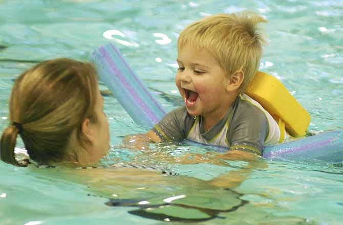 Abby Kemna and her 2-year-old son Harper practice kicking during their Saturday morning Parent Teacher swim class at the Jefferson City Knowles YMCA.