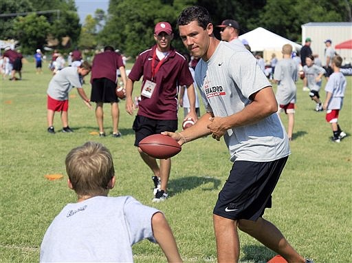 Rams quarterback Sam Bradford demonstrates a football handoff to a camper Wednesday in Norman, Okla.