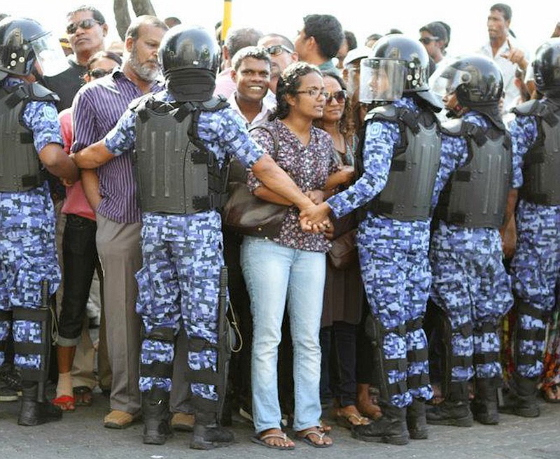 Shauna Aminath, center, a Westminster College of Fulton graduate, is held back by Republic of Maldives riot police during a recent demonstration calling for a return to democracy in the Island nation off the tip of India.