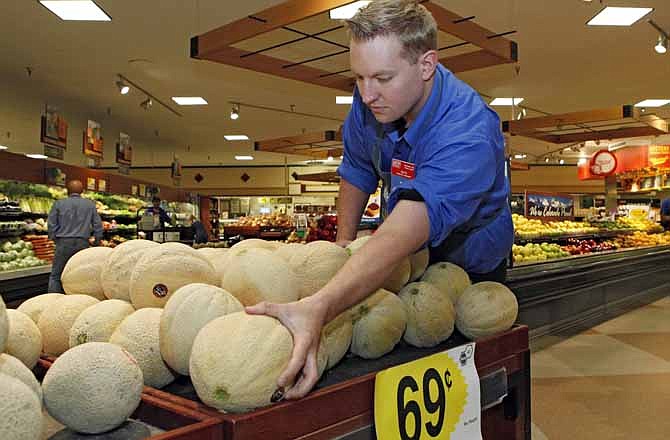 Produce manager Nate Codina arranges a display of Rocky Ford cantaloupes at a Denver Kings Soopers market on Friday, July 13, 2012. Colorado cantaloupes are back in supermarkets Friday, and growers of the Rocky Ford melons are going on the offensive to restore the fruit's reputation a year after Colorado melons caused a deadly nationwide listeria outbreak. Farmers have banded together to trademark the melons and fund a new tracking system to prevent future outbreaks.