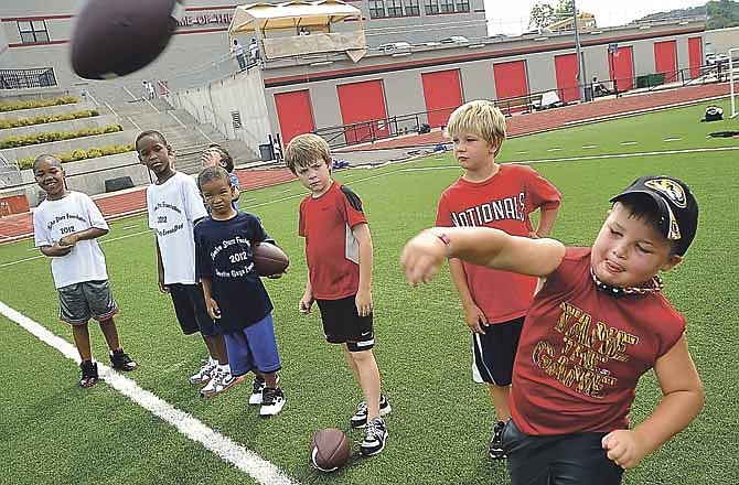 Connor Maloney sends the ball downfield as other participants watch and wait for their turn in the punt, pass and kick competition during the Twelve Starz Foundation Justin Gage Events Day at Adkins Stadium in Jefferson City on Saturday.