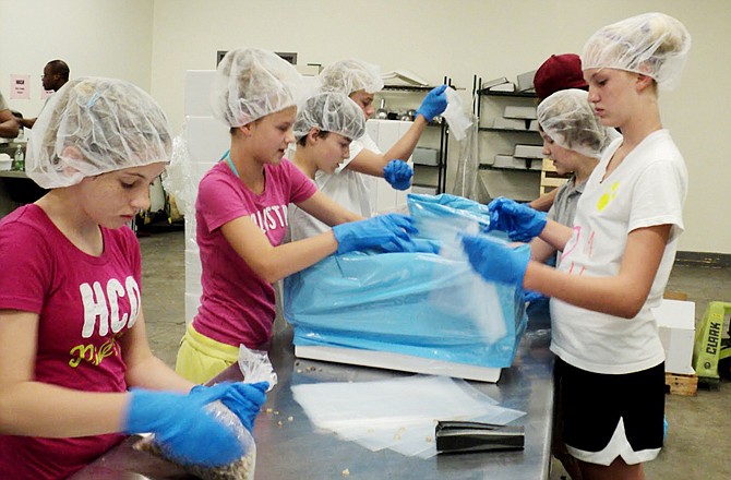 FILE: Volunteers process food at the Food Bank for Central and Northeast Missouri in Columbia. The food bank provides food for the Buddy Pack program that feeds needy children in Callaway County.