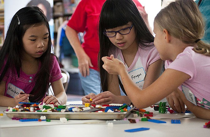 McKenzie Miller, 6, and big sister Reagan Miller, 9, along with Lauren Holsapple, 8, try to find the right LEGO to complete their LEGO house at the LEGO Block Party at Cedar Grove Baptist Church.