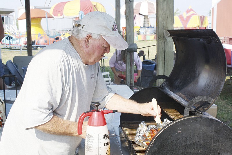 Bob Duncan of Fulton, brushes sauce onto his ribs at the 2011 Kingdom of Callaway County Fair. This year's barbecue challenge will be held Aug. 4.