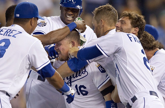 Billy Butler is surrounded by his Royals teammates after hitting a game-winning home run in the bottom of the ninth inning of Wednesday night's game against the Mariners at Kauffman Stadium.