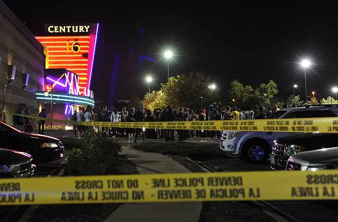 People gather outside the Century 16 movie theatre in Aurora, Colo., at the scene of a mass shooting early Friday morning, July 20, 2012. Police Chief Dan Oates says 14 people are dead following the shooting at the suburban Denver movie theater.