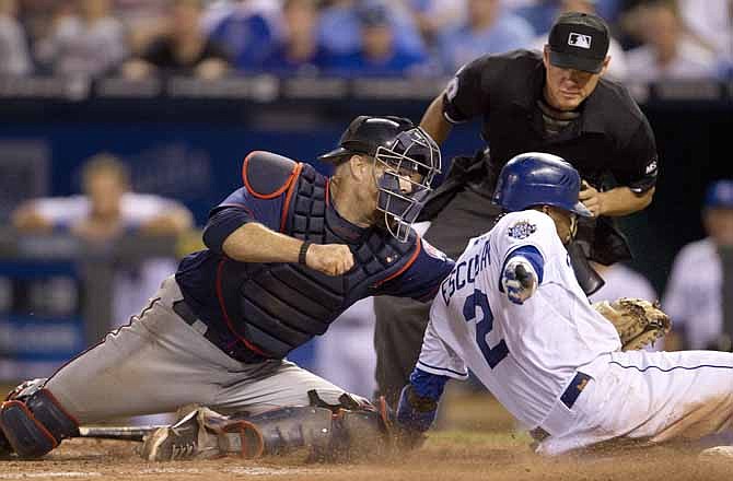 Minnesota Twins catcher Ryan Doumit, left, tags out Kansas City Royals' Alcides Escobar (2) during the eleventh inning of a baseball game at Kauffman Stadium in Kansas City, Mo., Friday, July 20, 2012. Home plate umpire D.J. Reyburn, back, looks to make the call. The Twins defeated the Royals 2-1 in eleven innings.