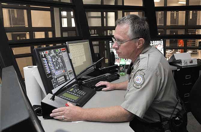 In this July 22, 2012 photo, jailer Gary Allen addresses inmates in their pods over a speaker system at the Cole County Jail.