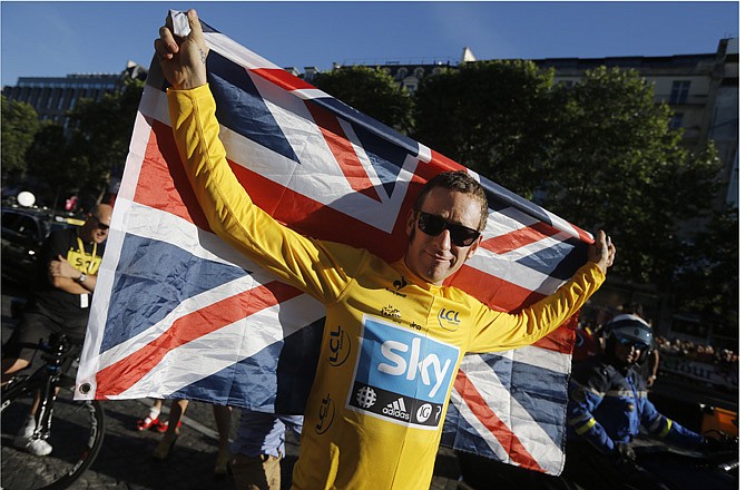 Bradley Wiggins, winner of the Tour de France, holds the Union Jack during the team parade Sunday in Paris, France.