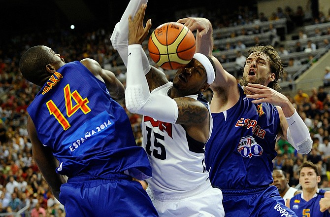 Carmelo Anthony of the U.S. (center) dives for the ball against Serge Ibaka of Spain (left) and Pau Gasol during an exhibition match between Spain and the United States on Tuesday in Barcelona, Spain, in preparation for the 2012 Summer Olympics.