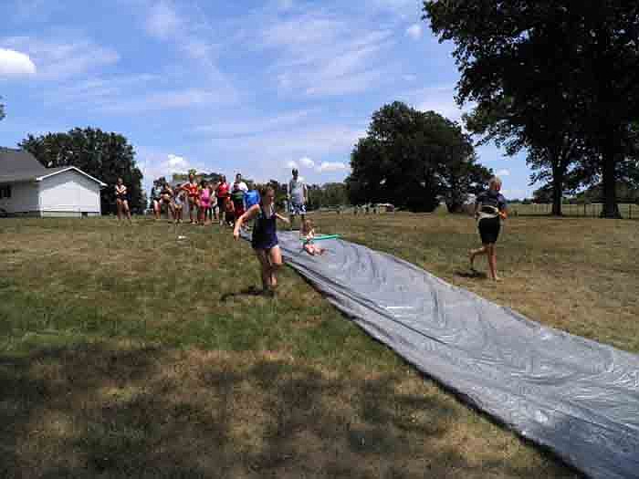 Children play on the slip and slide during the water games.