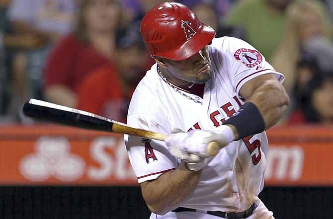 Los Angeles Angels' Albert Pujols swings at a pitch from Kansas City Royals' Will Smith in the third inning of a baseball game in Anaheim, Calif., Tuesday, July 24, 2012. The pitch his Pujols on the left wrist.