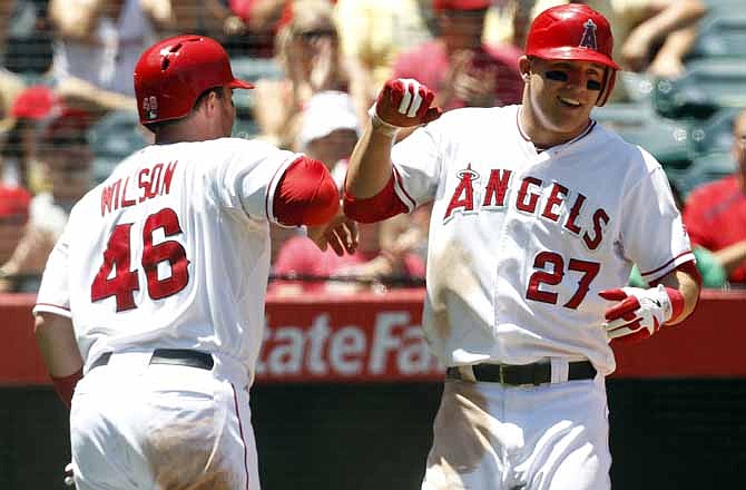 Los Angeles Angels' Bobby Wilson (46) is congratulated by Mike Trout after hitting a solo home run in the fourth inning of a baseball game against the Kansas City Royals in Anaheim, Calif., on Wednesday, July 25, 2012.