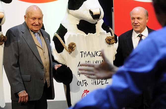 In this Monday, Dec. 14, 2009 picture, Chick-fil-a founder Truett Cathy, left, and his son Dan Cathy pose for a photo with the Chick-fil-A cows during a celebration of passing the $3 billon dollar mark in system-wide sales for the first time at the Chick-fil-a headquarters in Atlanta. Chick-fil-A, whose founder distinguished the fast-food chain by closing on Sunday out of religious piety, continues to mix theology with business and finds itself on the front lines of the nation's culture wars after its president, Dan Cathy, confirmed his opposition to gay marriage in June 2012.