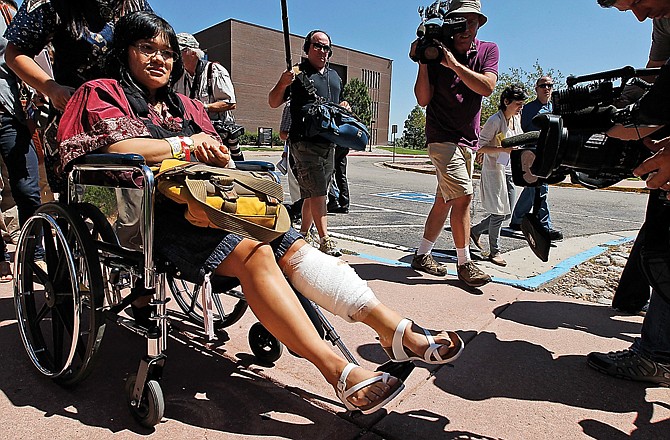 Rita Paulina, in wheelchair, who was injured in the attack, departs the Arapahoe County Courthouse after an arraignment hearing for accused theater shooter James Holmes.