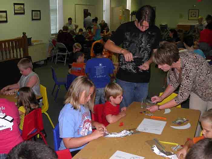 Children make silvery moon ornaments during the craft activity after the kindergarten through fourth grade storytime held Thursday, July 26.