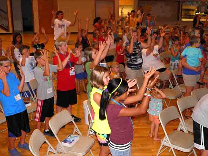 Children sing "Indescribable" during worship.