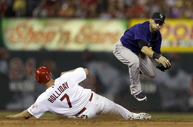 Colorado Rockies shortstop Marco Scutaro, right, fails to turn the double play as St. Louis Cardinals' Matt Holliday is safe at second during the fifth inning of a baseball game Monday, July 2, 2012, in St. Louis. The Cardinals' Carlos Beltran was safe at first. 