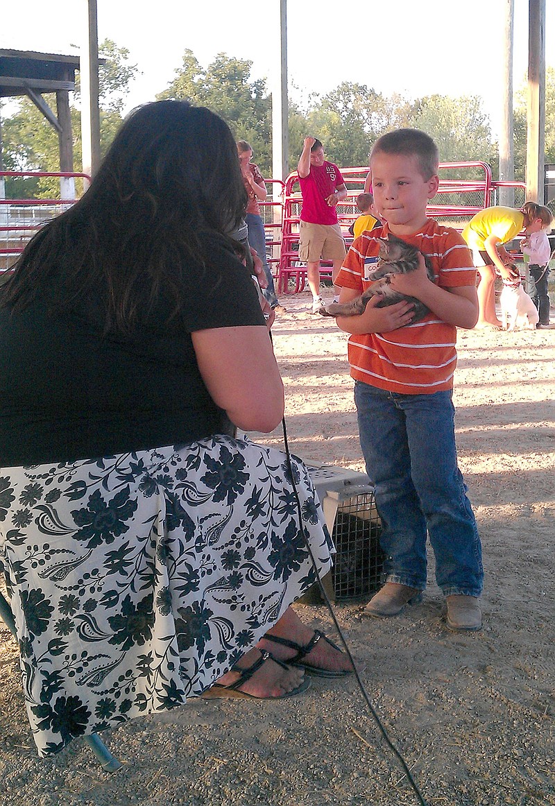 Six-year-old Colin Humphreys of Fulton shows his kitten, Opie, during the special Children's Small Animal Show at the Kingdom of Callaway County Fair Thursday night. Eleven area children shared their favorite pet or small livestock animal with judge Danene Beedle of Columbia.