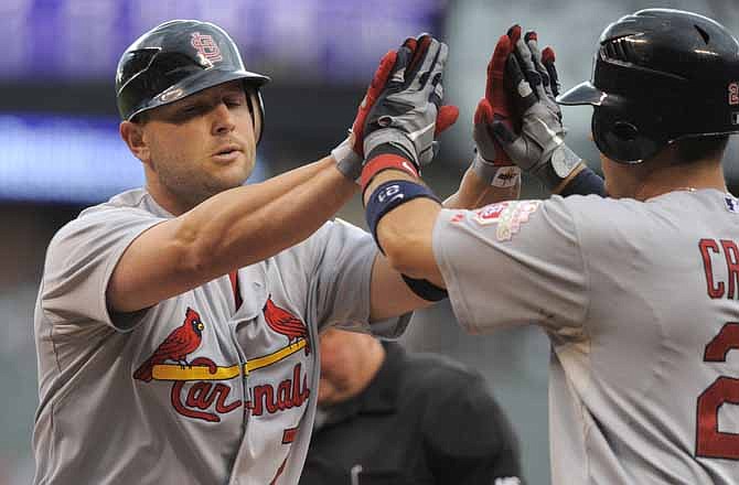 St. Louis Cardinals' Matt Holliday (7) high-fives teammate Allen Craig after hitting a two-run home run off Colorado Rockies starting pitcher Drew Pomeranz during the first inning of a baseball game, Wednesday, Aug. 1, 2012, in Denver. 