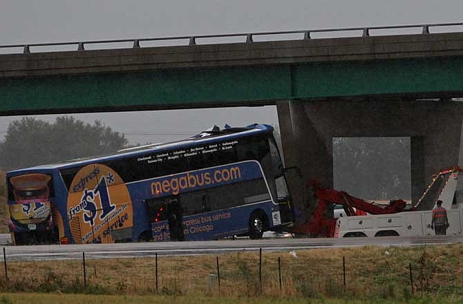 The Megabus is pulled away from the bridge support Thursday evening Aug. 2, 2012 on southbound Interstate 55 north of Litchfield, Ill. The packed double-decker Megabus slammed into an Illinois interstate bridge support pillar Thursday, hurtling screaming passengers from their seats and leaving at least one person dead and more than three dozen injured, officials said.