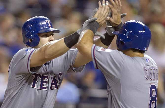 Texas Rangers' Mitch Moreland, left, is congratulated by Geovany Soto following his three-run home run off Kansas City Royals relief pitcher Jose Mijares during the seventh inning of a baseball game at Kauffman Stadium in Kansas City, Mo., Friday, Aug. 3, 2012.