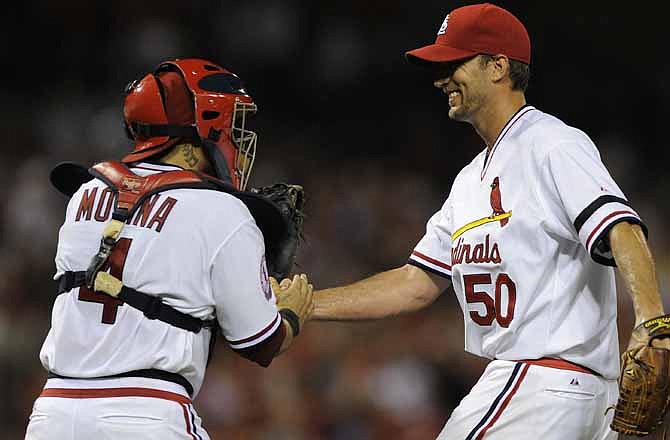 St. Louis Cardinals starting pitcher Adam Wainwright (50) is congratulated by catcher Yadier Molina after throwing a complete baseball game against the Milwaukee Brewers Saturday, Aug. 4, 2012, in St. Louis. The Cardinals won 6-1.