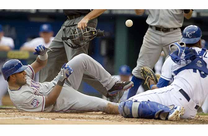 Texas Rangers' Elvis Andrus, left, slides into home plate while Kansas City Royals catcher Salvador Perez (13) tries to control the ball during the third inning of a baseball game at Kauffman Stadium in Kansas City, Mo., Saturday, Aug. 4, 2012. Andrus scored on a single by teammate Josh Hamilton.
