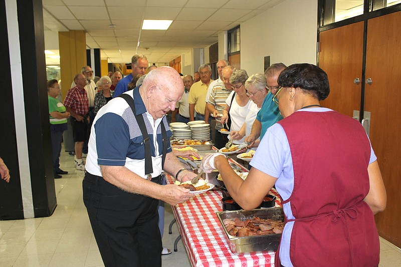 Attendees of the Kingdom of Callaway County Fair's annual Ham Breakfast line up for eggs, biscuits and country ham cured by area 4-H youth Saturday morning. 