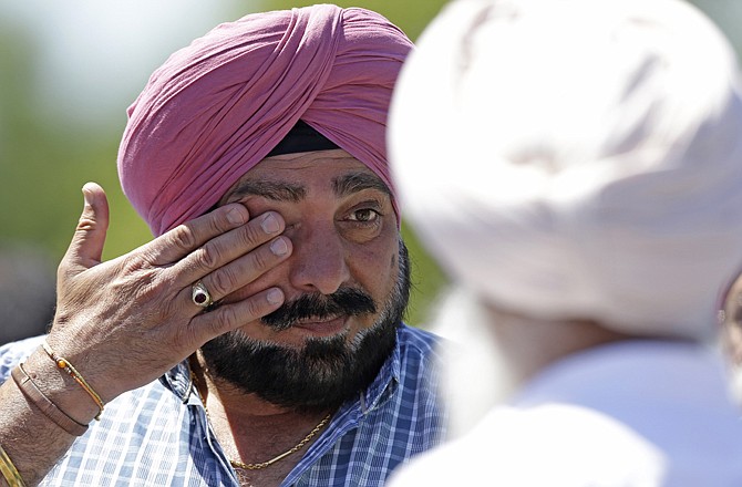 A man reacts outside the Sikh Temple of Wisconsin in Oak Creek, Wis., where a deadly shooting took place on Sunday.