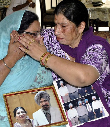 Harinder Kaur Rakhra, left, sister of shooting victim Satwant Singh Kaleka, is consoled Monday by Seema Sharma, a local politician in Patiala, India. Kaleka's actions fighting against the gunman gave women and children time to take cover in the Wisconsin Sikh temple under attack.