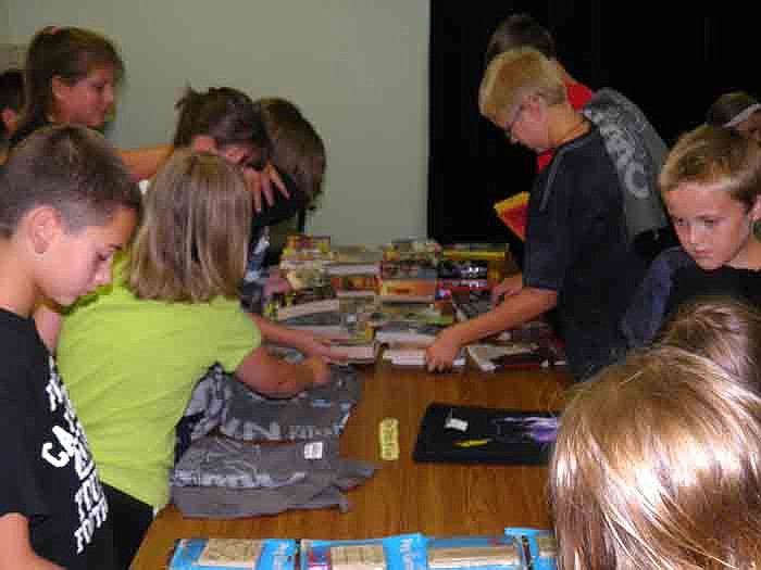 Tweens and teen who participated in the "Own the Night" Summer Reading Club use tickets they earned throughout the summer to purchase books and prizes during the pizza party held Friday, Aug. 3, at Wood Place Public Library, California.