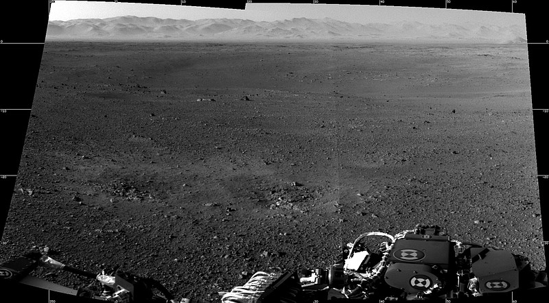 A mosaic of the first two full-resolution images of the Martian surfaceis shown from the Navigation cameras on NASA's Curiosity rover. The rim of Gale Crater can be seen in the distance beyond the pebbly ground. The foreground shows two distinct zones of excavation likely carved out by blasts from the rover's descent stage thrusters.