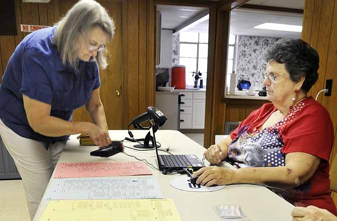 
Cole County election judge, Grace Cross, right, assists Kathy Gander as she signs in prior to casting her ballot Tuesday at Jefferson City's Ward 1/Precinct 2 polling place in the basement of Calvary Baptist Church. Cross has been an election worker for about 10 years, and Gander said she's been casting her vote at this location for a number of years also.